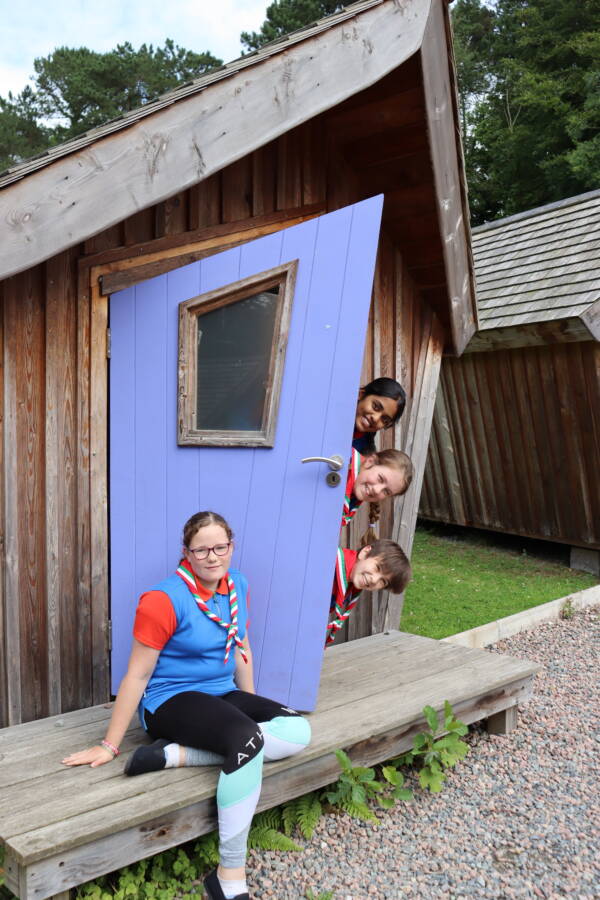 Photo depicting four girls at a wooden cabin